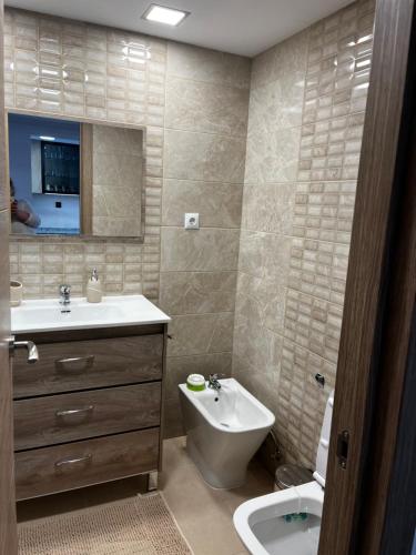 a bathroom with a sink and a toilet and a mirror at VERANO AZUL in Benidorm