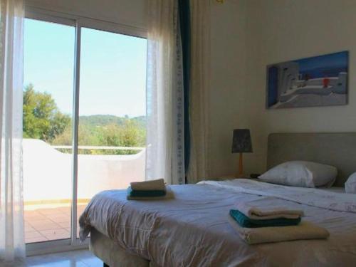 a bedroom with a bed and a large window at Villa Blanca in Calonge