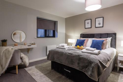 um quarto com uma cama grande e almofadas azuis em Luxury apartment 5 min to city centre*free parking em Newcastle upon Tyne