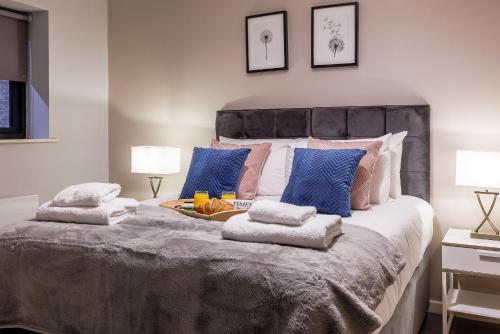 um quarto com uma cama grande e almofadas azuis em Luxury apartment 5 min to city centre*free parking em Newcastle upon Tyne