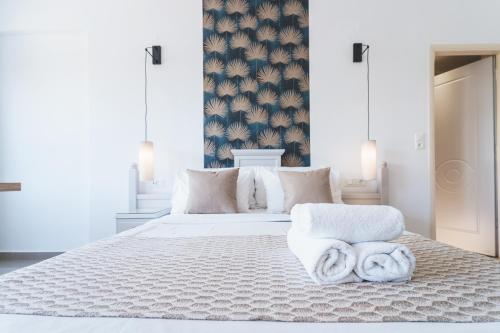 a bedroom with a large white bed with towels on it at Zeus Village Resort - Adults Only in Kato Daratso