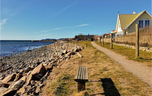 a bench sitting on the side of a rocky beach at 3 Bedroom Awesome Home In Nyhamnsläge in Nyhamnsläge