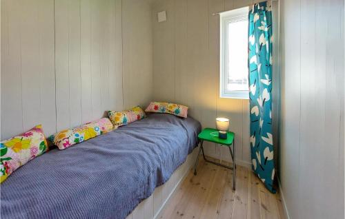 two beds in a small room with a window at Lovely Home In Nyhamnslge With House Sea View in Nyhamnsläge