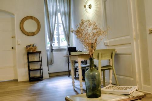 um vaso com flores numa mesa num quarto em La Verrière - Chambre d'hôtes et gîte de charme em Poligny