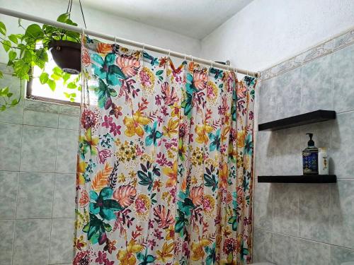 uma cortina de chuveiro com um padrão floral na casa de banho em Tu Casa en el Caribe em Cancún