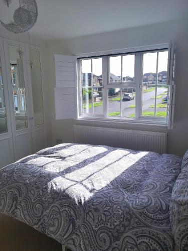 a bedroom with a bed and a large window at BIENVENUE in NEWHAVEN Luxury superking OR standard OR budget rooms in Newhaven