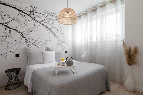 een witte slaapkamer met een bed en een tafel bij KENYA parking gratuit in Annecy