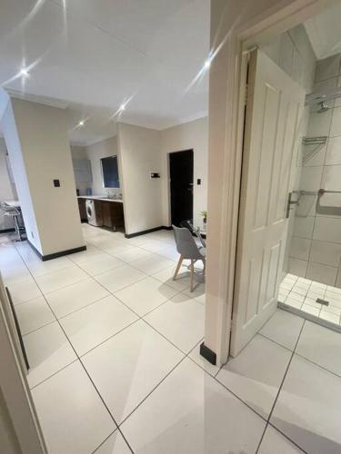 une grande pièce avec un sol en carrelage blanc et une salle de bain dans l'établissement Priceless Cove. Garden Cottage, à Midrand