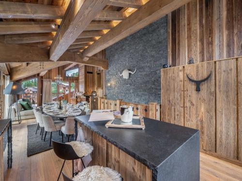 d'une salle à manger avec une table, des chaises et des murs en bois. dans l'établissement Chalet neuf à Saint Martin de Belleville, 200m des pistes, spa privé, 10 personnes - FR-1-570-31, à Saint-Martin-de-Belleville