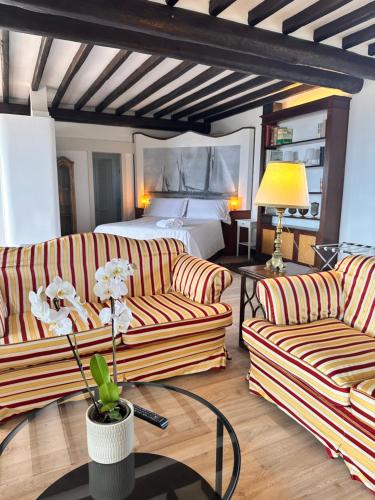 a living room with two couches and a bed at Piccadilly Penthouse with Jacuzzi in Lido di Camaiore