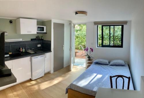 - une cuisine avec une table et un lit bleu dans une chambre dans l'établissement Studio indépendant terrasse piscine, à Avignon