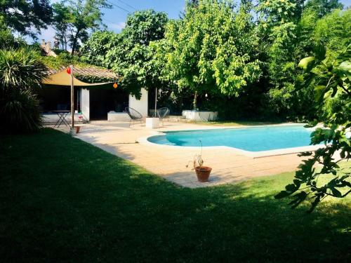 une piscine dans une cour à côté d'une maison dans l'établissement Studio indépendant terrasse piscine, à Avignon