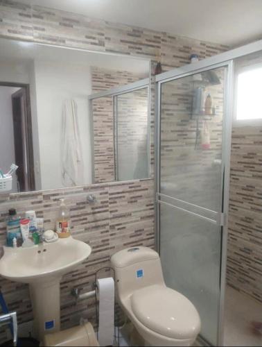y baño con aseo, lavabo y ducha. en Bright Duplex 2 bedroom Apartment, kitchen, bathroom & living room, en Cartagena de Indias