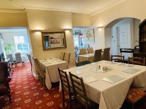 a dining room with white tables and chairs at Fairlight Guesthouse in Glenridding