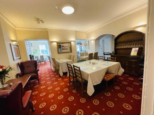 a dining room with two tables and a piano at Fairlight Guesthouse in Glenridding