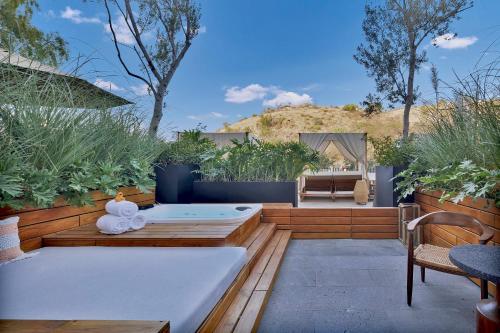 a patio with a bench and tables and plants at Live Aqua San Miguel de Allende in San Miguel de Allende