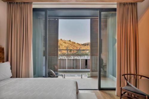 a bedroom with a bed and a view of a balcony at Live Aqua San Miguel de Allende in San Miguel de Allende