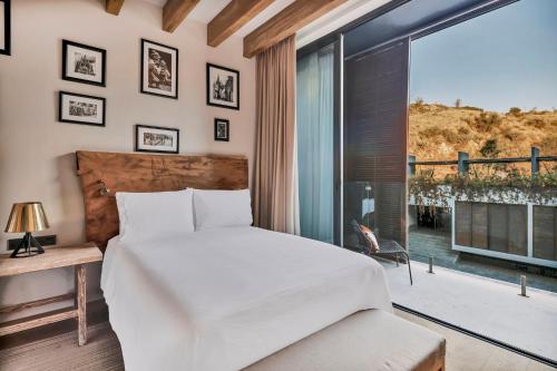 a bedroom with a bed and a large window at Live Aqua San Miguel de Allende in San Miguel de Allende