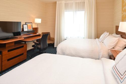 a hotel room with two beds and a desk with a computer at Fairfield Inn & Suites by Marriott Hollister in Hollister