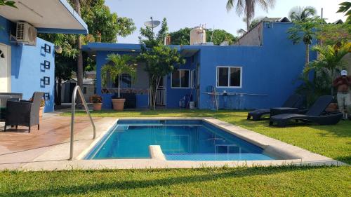 a swimming pool in the yard of a house at VIP Trailer Park and Bungalows. in Barra de Navidad