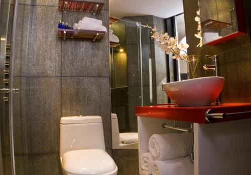 baño con lavabo rojo y aseo en Hotel City Bog Expo Museo, en Bogotá