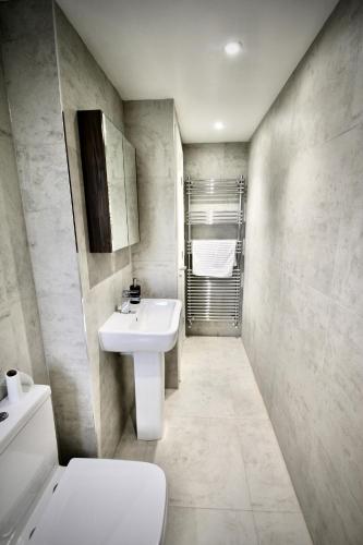 a bathroom with a white sink and a toilet at Mill House Townhouse in Newmarket