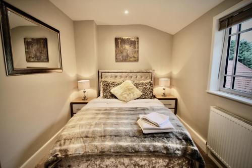 a bedroom with a bed with two lamps and a window at Mill House Townhouse in Newmarket