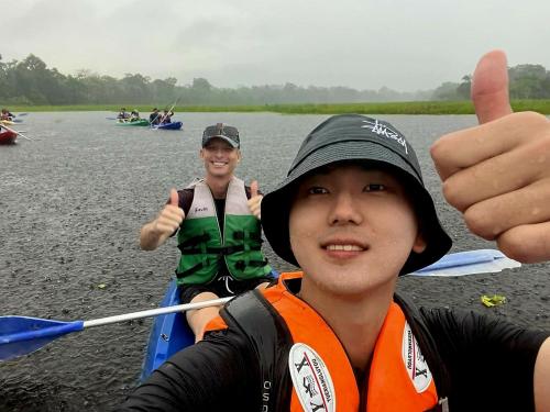 a young man giving a thumbs up while kayaking on a river at Kanaq Hotel Tours in Leticia