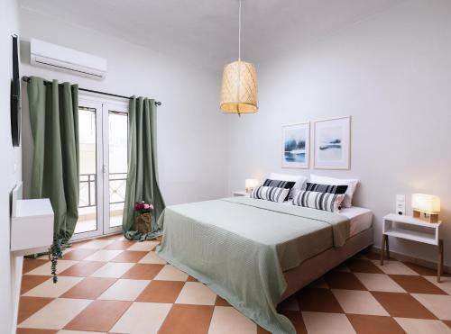 a bedroom with a large bed with green curtains at Hospitium Crete in Moírai