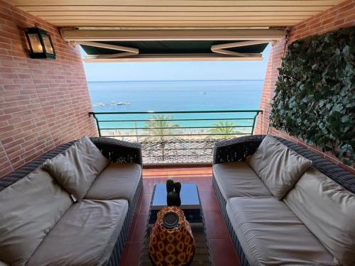 a couch on a balcony with a view of the ocean at Sesimbra Retreat by the Sea in Sesimbra