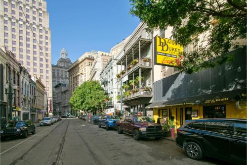 une rue urbaine animée avec des voitures garées dans la rue dans l'établissement Roami at Bourbon Place, à La Nouvelle-Orléans