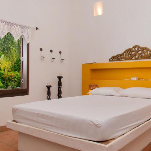 a bedroom with a large white bed and a window at Casa Guali in Honda