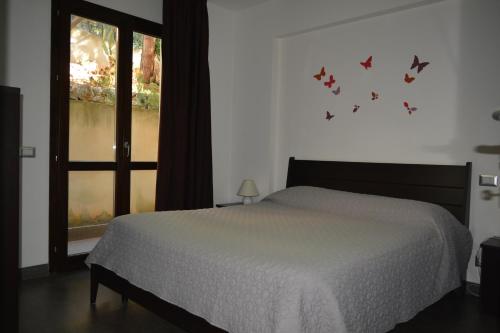 um quarto com uma cama com borboletas na parede em Casa Paola em Monreale