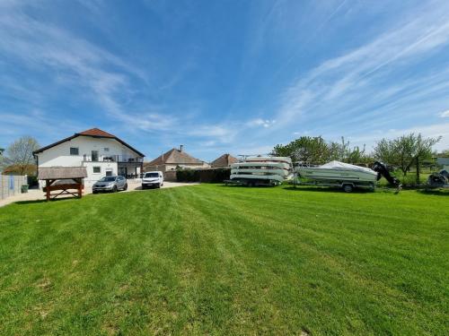 a yard with two rvs parked in the grass at Duna-Beach Apartman in Kimle