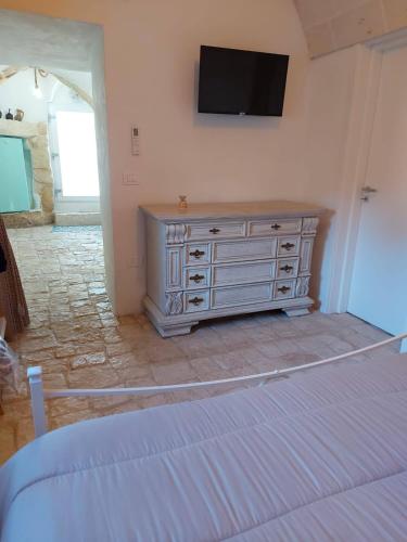 a bedroom with a dresser with a television on the wall at Le Pajare B&b in Sava