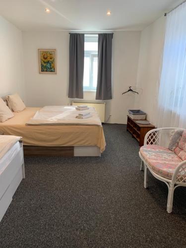 sypialnia z łóżkiem, krzesłem i oknem w obiekcie Apartmán U Kostela w Podiebradach