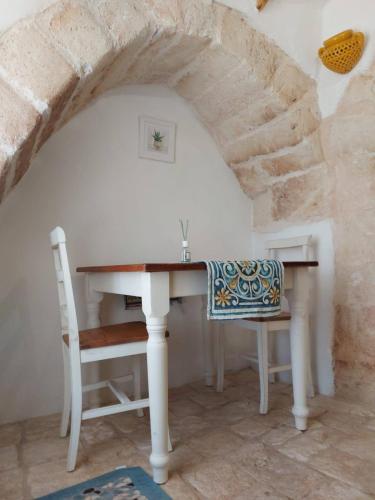 a table and chair in a room with a stone wall at Le Pajare B&b in Sava