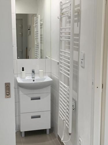 Baño blanco con lavabo y espejo en Apartmán U Kostela en Poděbrady