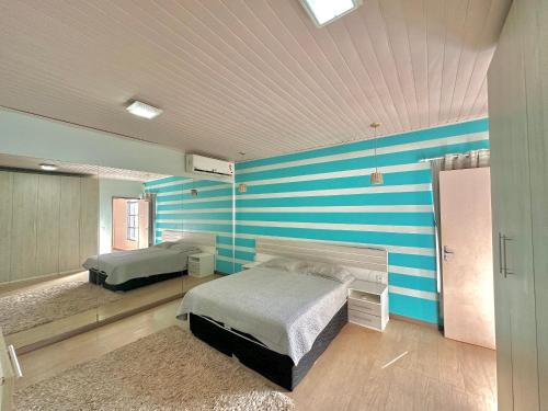 a bedroom with two beds and blue and white stripes at Pousada Residencial - PVH in Porto Velho