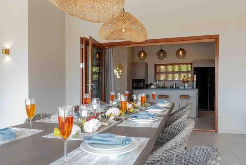 a long dining table with plates and glasses on it at Villa Vista Valentin in Willemstad