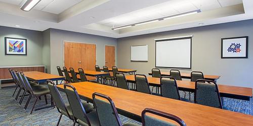 a conference room with wooden tables and chairs at Holiday Inn Express Silver Springs - Ocala by IHG in Silver Springs
