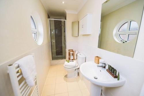 a white bathroom with a toilet and a sink at ! LARGE ! Apartment Central Leatherhead Sleeps 6! in Leatherhead