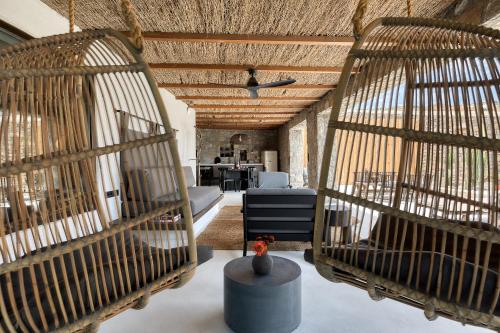 two birds cages in a room with a table at Rocabella Mykonos Hotel in Agios Stefanos