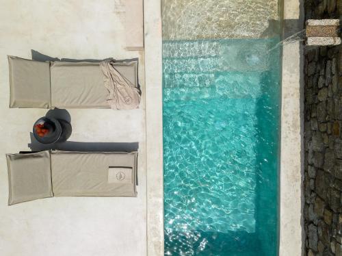 an overhead view of a swimming pool and water at Rocabella Mykonos Hotel in Agios Stefanos
