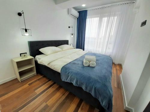 a bedroom with a bed with two towels on it at Modern Apartment Near Airport in Chişinău