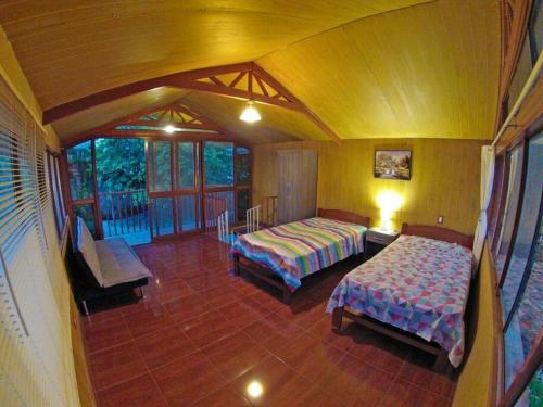 a large room with two beds and a balcony at Casita Grau 2! Naturaleza y confort con Agua caliente,cocina y frigobar in Tarapoto