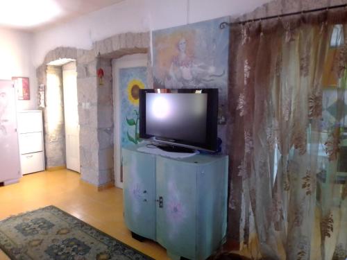 a television sitting on a stand in a room at Apartman SIRENA in Pićan