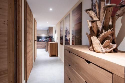 una cocina con armarios de madera y un largo pasillo con troncos en APPALACHES Annecy Rent Lodge, en Annecy