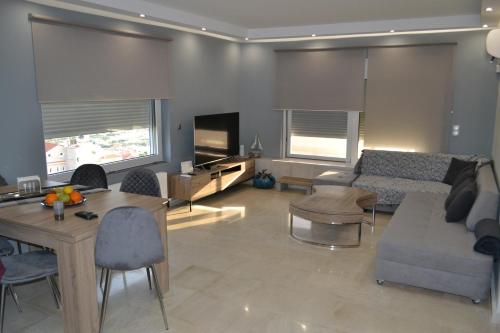un soggiorno con divano e tavolo di Stergiou Luxury Apartments with shared pool ad Anávissos
