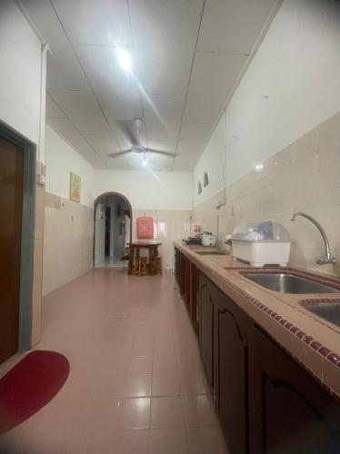 eine große Küche mit einer Theke und einem Waschbecken in der Unterkunft Huda Homestay Bandar Tanah Merah in Distrikt Tanah Merah